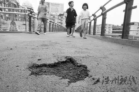 天桥刚修通就破相了，市民唯恐一脚下去踩出个窟窿，跌落地面