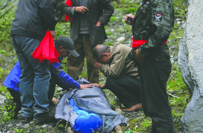 女驴友遇难，警民抬担架遇难者遗体出山