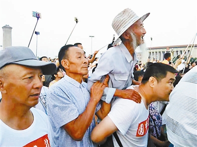 民警背老人看升旗